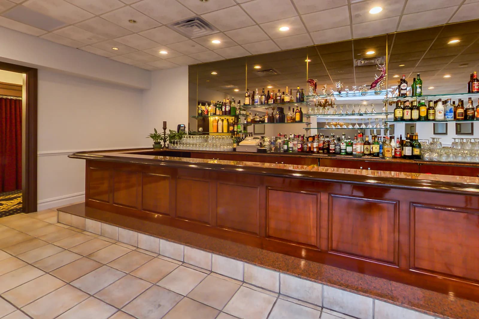 Lounge bar at Macaluso's in Hawthorne, NJ, with a curved wood bar, mirrored back bar and gold-linen tables