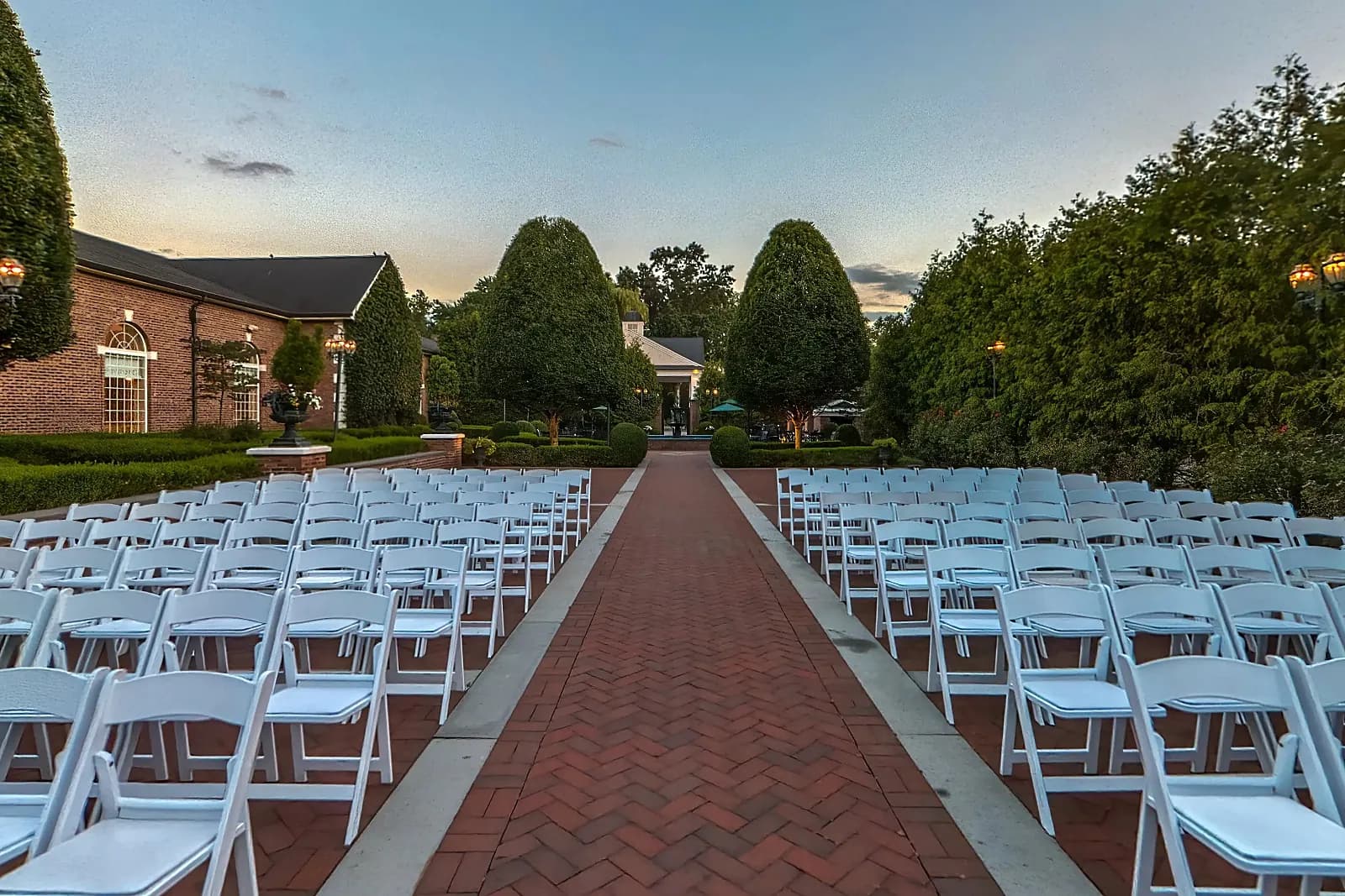 Outdoor ceremony chairs along a brick aisle in the gardens at The Rockleigh