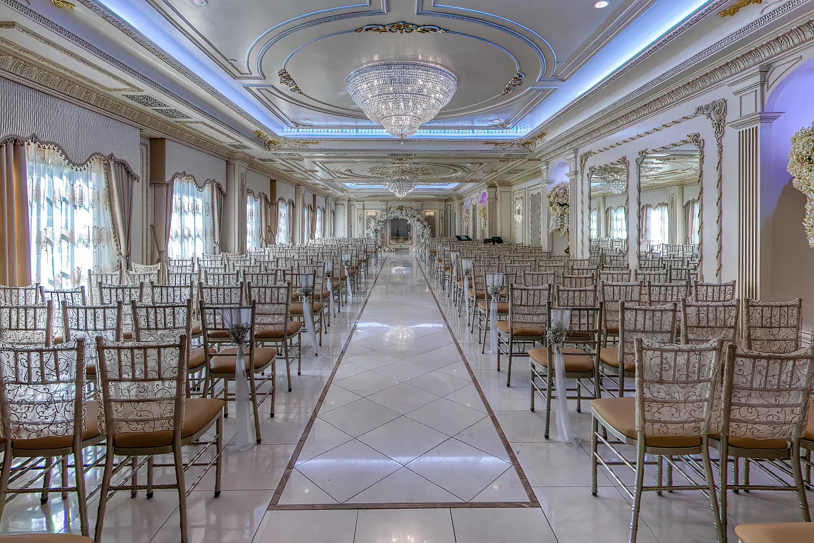 Chapel at The Venetian in Garfield, NJ, with gold chairs along a marble aisle, crystal chandeliers and draped windows