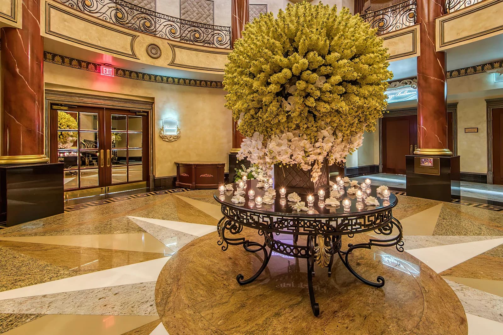 Rotunda at The Venetian in Garfield, NJ, with a floral centerpiece, red marble columns and an ironwork staircase