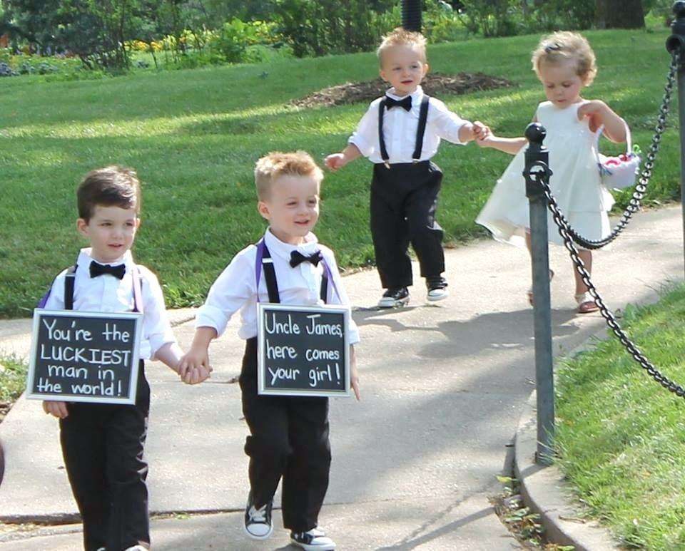 luckiest man in the world sign held by ring bearers strolling down to the ceremony