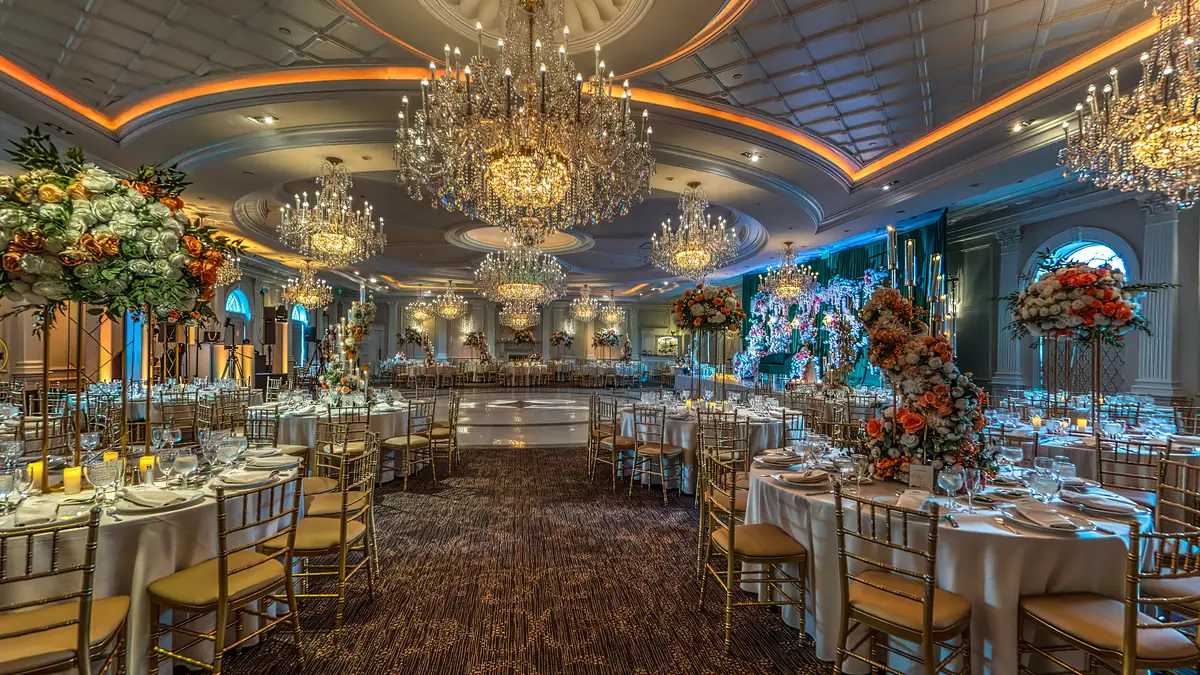 The Rockleigh Grand Pavilion ballroom fully dressed on a real wedding evening — chandeliers glowing, tables set with florals and candlelight